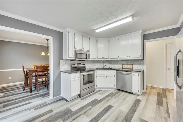 5407 Palmetto Ct, Flowery Branch, GA 30542 - kitchen featuring appliances with stainless steel finishes, a sink, dark countertops, light wood-style floors, and backsplash