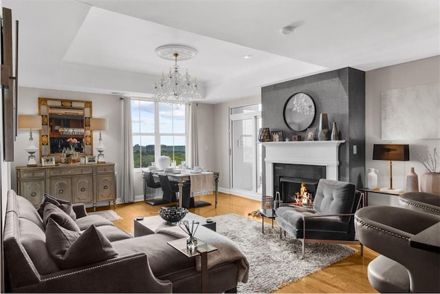 2881 Peachtree Rd NE Unit 1102, Atlanta, GA 30305 - living room with a chandelier, a tray ceiling, a lit fireplace, and baseboards