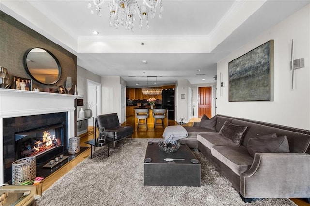 2881 Peachtree Rd NE Unit 1102, Atlanta, GA 30305 - living area with a chandelier, wood finished floors, a lit fireplace, ornamental molding, and a raised ceiling