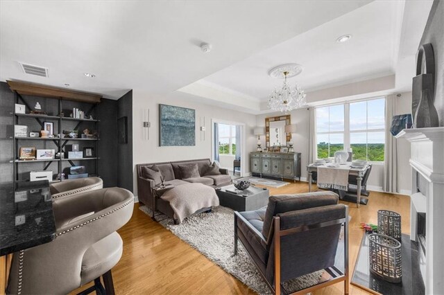 2881 Peachtree Rd NE Unit 1102, Atlanta, GA 30305 - living area featuring a chandelier, a fireplace, wood finished floors, a raised ceiling, and recessed lighting