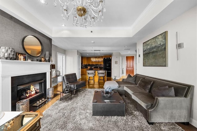 2881 Peachtree Rd NE Unit 1102, Atlanta, GA 30305 - living room with wood finished floors, a chandelier, a warm lit fireplace, baseboards, and a tray ceiling