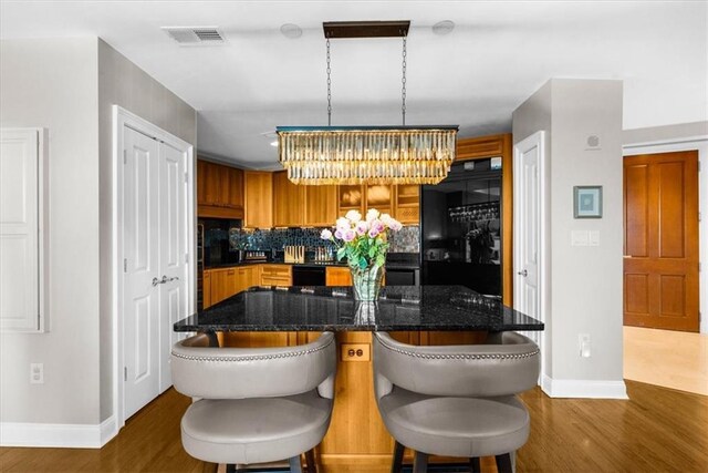 2881 Peachtree Rd NE Unit 1102, Atlanta, GA 30305 - kitchen with a chandelier, baseboards, black fridge, and dark wood-style flooring