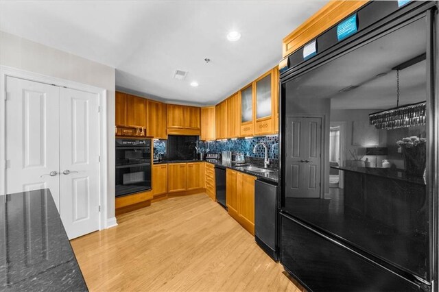 2881 Peachtree Rd NE Unit 1102, Atlanta, GA 30305 - kitchen with black appliances, light wood-type flooring, tasteful backsplash, a sink, and dark stone counters