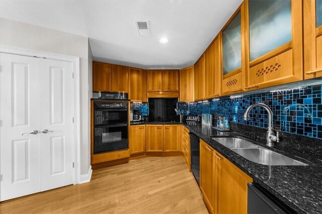 2881 Peachtree Rd NE Unit 1102, Atlanta, GA 30305 - kitchen featuring a sink, black appliances, dark stone counters, brown cabinetry, and light wood finished floors