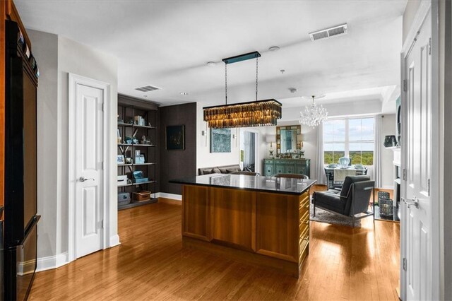 2881 Peachtree Rd NE Unit 1102, Atlanta, GA 30305 - kitchen featuring open floor plan, dark countertops, a chandelier, dark wood-style flooring, and a center island