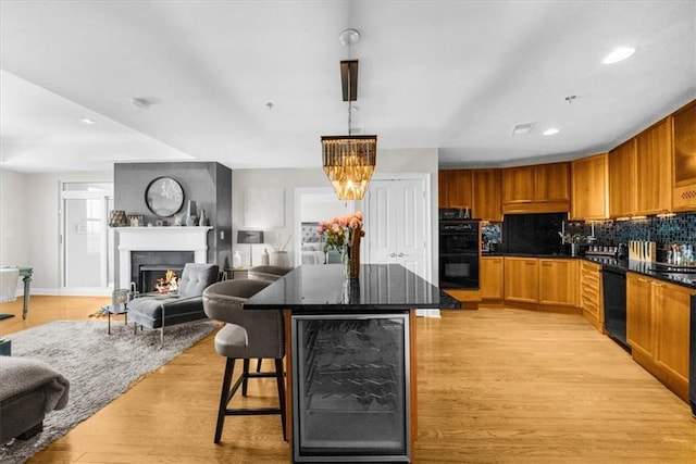 2881 Peachtree Rd NE Unit 1102, Atlanta, GA 30305 - kitchen featuring wine cooler, open floor plan, black appliances, light wood-style flooring, and tasteful backsplash