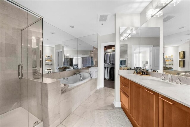 2881 Peachtree Rd NE Unit 1102, Atlanta, GA 30305 - bathroom featuring a garden tub, vanity, a stall shower, and a walk in closet