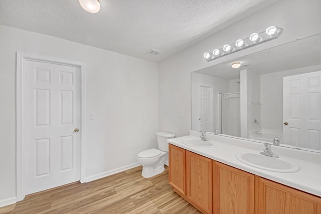7459 Old Chapel, South Fulton, GA 30349 - full bathroom with a shower, double vanity, a textured ceiling, toilet, and wood finished floors