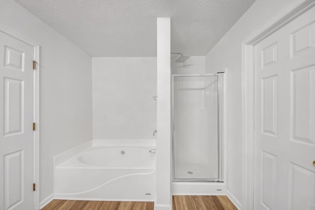 7459 Old Chapel, South Fulton, GA 30349 - bathroom featuring wood finished floors, a stall shower, a garden tub, and a textured ceiling