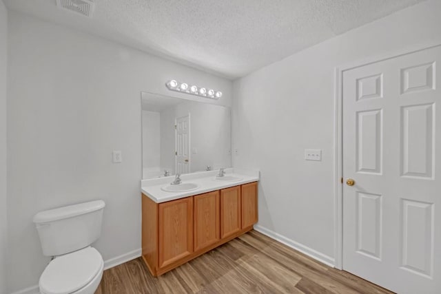 7459 Old Chapel, South Fulton, GA 30349 - full bath featuring a textured ceiling, wood finished floors, double vanity, toilet, and baseboards