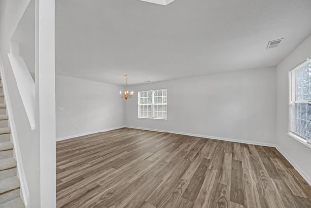 7459 Old Chapel, South Fulton, GA 30349 - spare room with wood finished floors, a chandelier, stairway, and baseboards