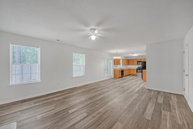 7459 Old Chapel, South Fulton, GA 30349 - unfurnished living room with light wood-type flooring, ceiling fan, baseboards, and a textured ceiling
