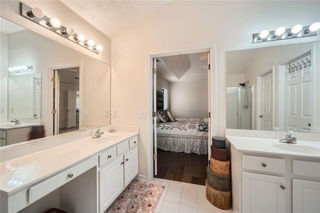 ensuite bathroom with a sink, ensuite bath, and vaulted ceiling