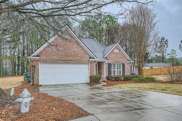 view of front of property with concrete driveway, an attached garage, fence, and brick siding