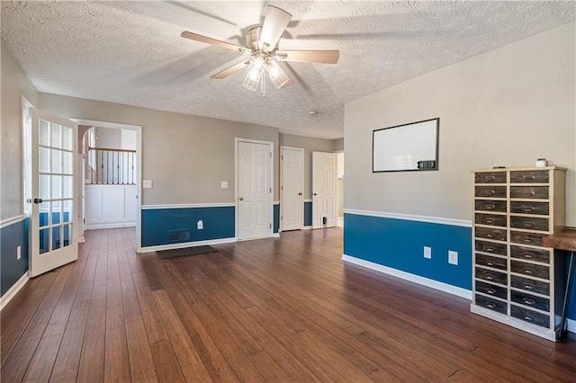 empty room with ceiling fan, baseboards, a textured ceiling, and hardwood / wood-style floors