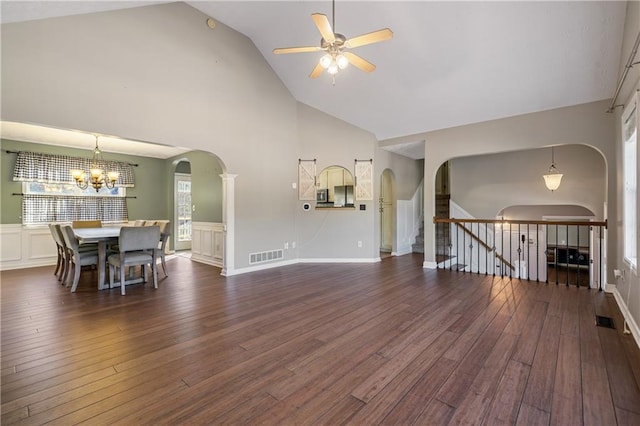 living room with visible vents, arched walkways, dark wood-style flooring, and ceiling fan with notable chandelier