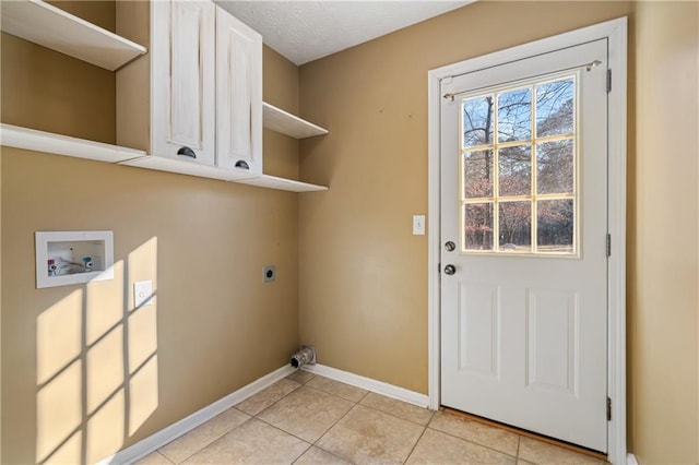 washroom featuring baseboards, hookup for a washing machine, light tile patterned flooring, cabinet space, and electric dryer hookup