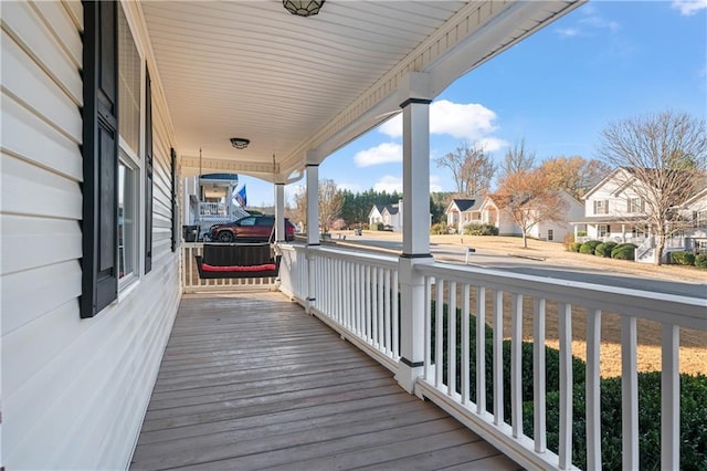 wooden terrace with a residential view and a porch