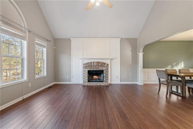 living room featuring dark wood-style floors, a fireplace, baseboards, and a ceiling fan