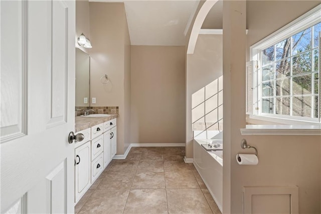 full bathroom featuring plenty of natural light, a garden tub, vanity, and tile patterned flooring