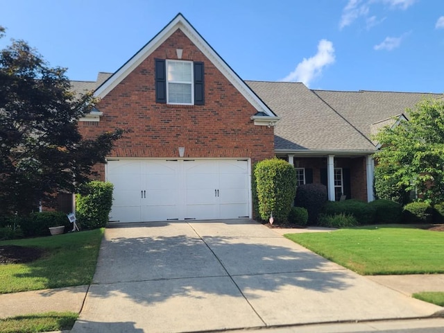 traditional-style house featuring brick siding, roof with shingles, concrete driveway, a garage, and a front lawn