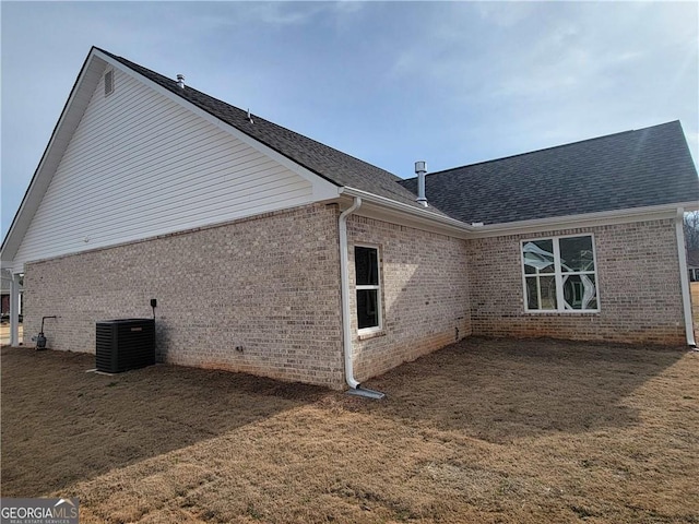 view of side of property with cooling unit and a lawn