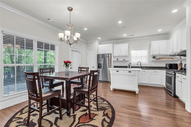 335 Pintail Ct, Suwanee, GA 30024 - dining room with crown molding, a chandelier, recessed lighting, and dark wood-style flooring