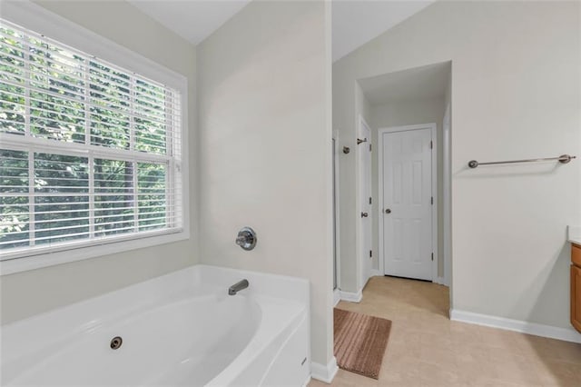 335 Pintail Ct, Suwanee, GA 30024 - full bathroom featuring healthy amount of natural light, a garden tub, vanity, baseboards, and vaulted ceiling