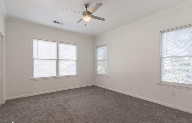 unfurnished room with visible vents, dark carpet, baseboards, and ornamental molding