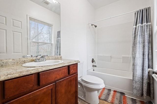 full bathroom featuring tile patterned flooring, toilet, vanity, visible vents, and shower / bath combo with shower curtain