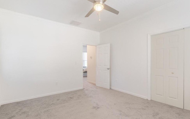 unfurnished room with baseboards, ornamental molding, a ceiling fan, and light colored carpet