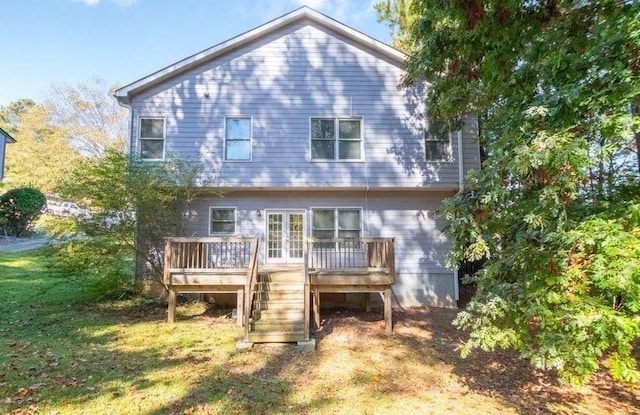 back of property with stairway, a wooden deck, and a lawn