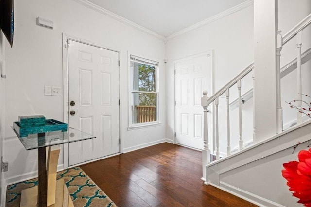 foyer featuring ornamental molding, dark wood finished floors, baseboards, and stairs