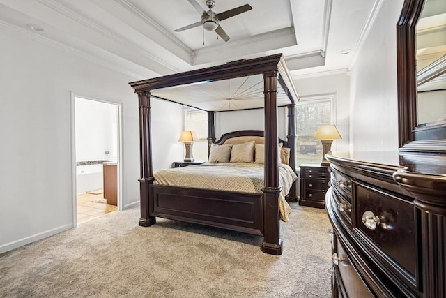 bedroom with light carpet, baseboards, connected bathroom, ornamental molding, and a tray ceiling