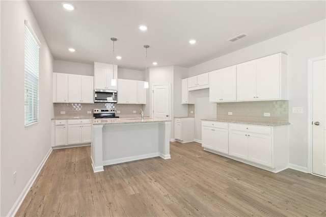 7127 Brushwood Bnd, Lithonia, GA 30058 - kitchen with visible vents, appliances with stainless steel finishes, decorative backsplash, and light wood-type flooring