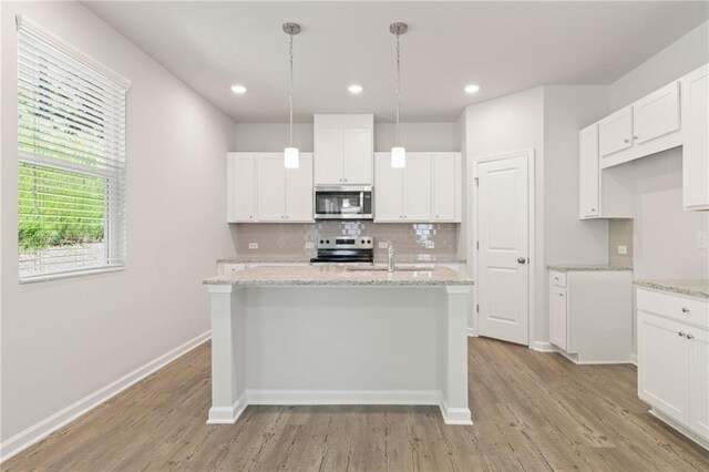 7127 Brushwood Bnd, Lithonia, GA 30058 - kitchen featuring appliances with stainless steel finishes, a sink, light wood finished floors, and backsplash
