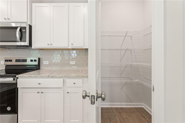 7127 Brushwood Bnd, Lithonia, GA 30058 - kitchen with white cabinets, wood finished floors, and stainless steel appliances