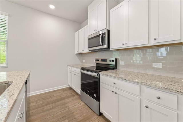 7127 Brushwood Bnd, Lithonia, GA 30058 - kitchen with light wood-type flooring, stainless steel appliances, backsplash, and white cabinets