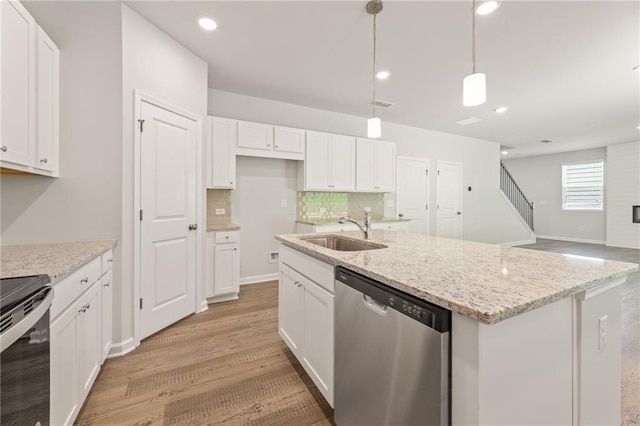7127 Brushwood Bnd, Lithonia, GA 30058 - kitchen with white cabinetry, a sink, stainless steel appliances, light wood-type flooring, and a kitchen island with sink