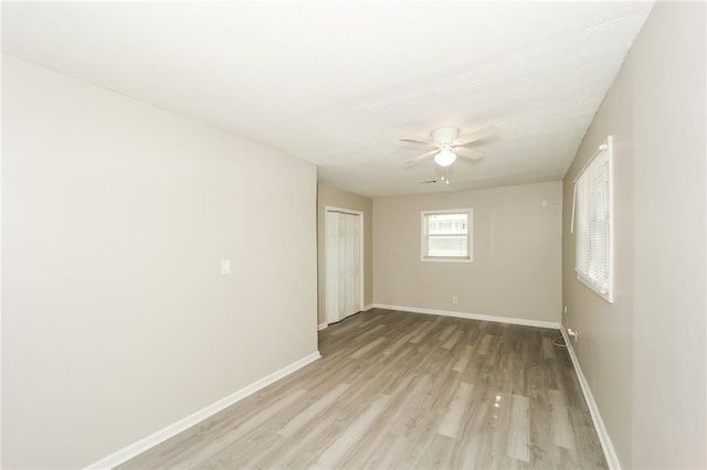 spare room with ceiling fan and light wood-type flooring