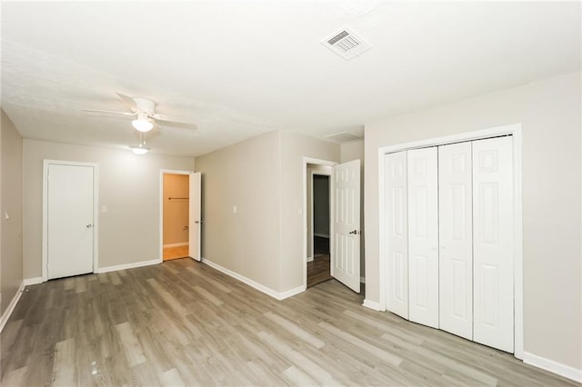 unfurnished bedroom featuring ceiling fan, a closet, and light wood-type flooring