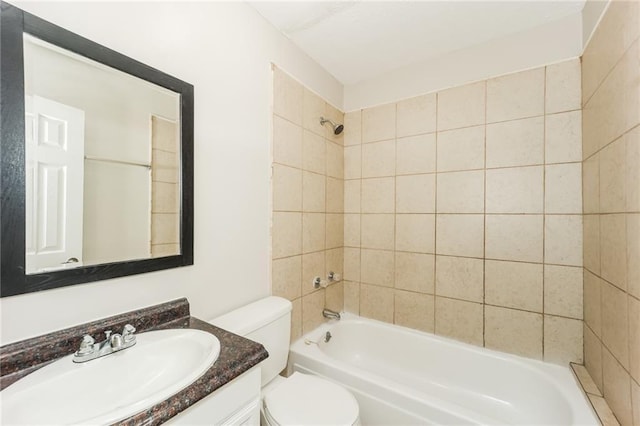 full bathroom with tiled shower / bath, vanity, and toilet