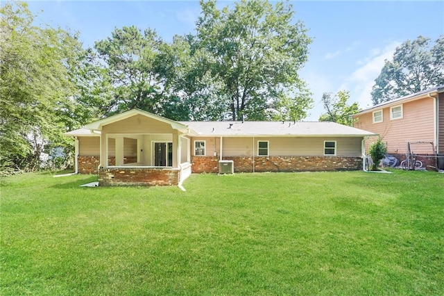 rear view of property with cooling unit and a lawn