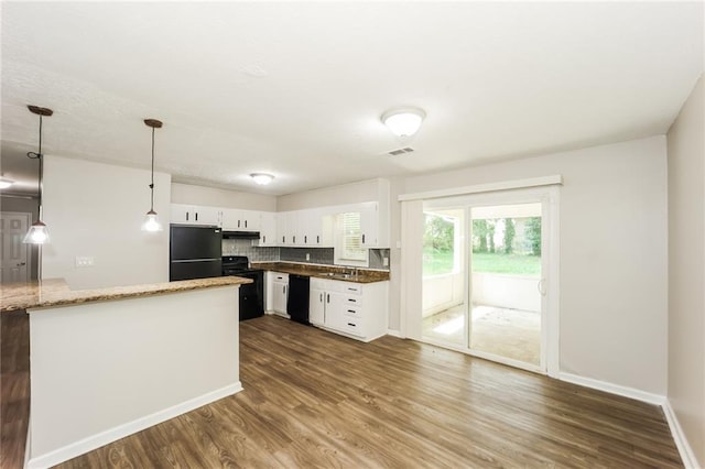 kitchen with tasteful backsplash, black appliances, white cabinets, dark hardwood / wood-style flooring, and decorative light fixtures