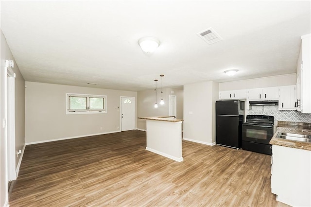 kitchen with white cabinets, backsplash, hanging light fixtures, black appliances, and light hardwood / wood-style flooring