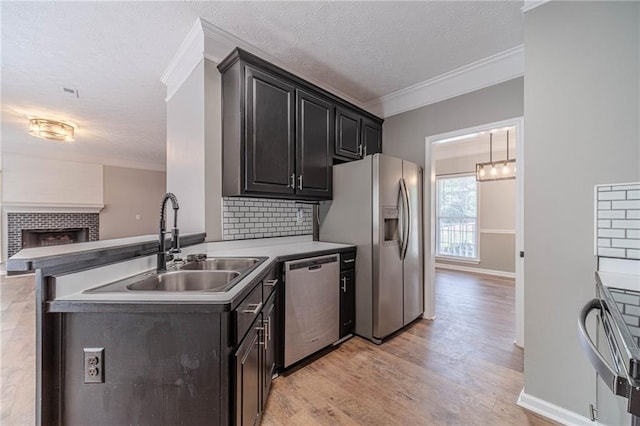 206 Belmont Dr, Monroe, GA 30655 - kitchen with stainless steel appliances, a sink, crown molding, light wood-style floors, and backsplash