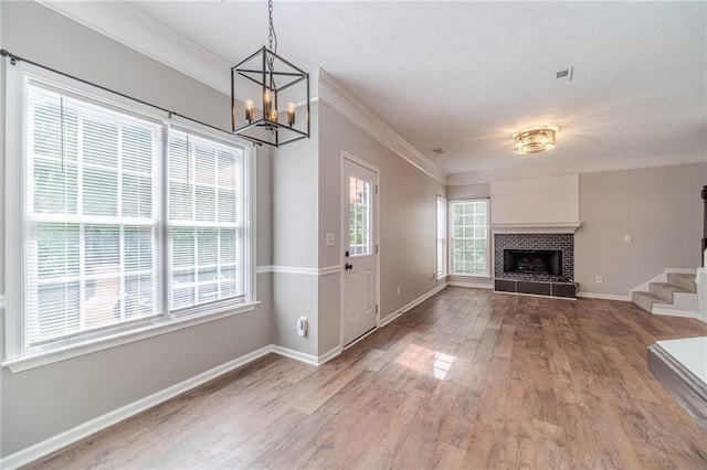 206 Belmont Dr, Monroe, GA 30655 - unfurnished living room featuring wood finished floors, a chandelier, ornamental molding, baseboards, and a tile fireplace