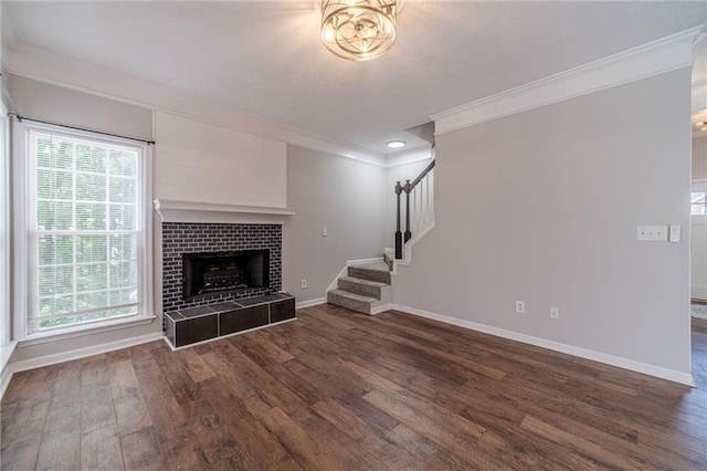 206 Belmont Dr, Monroe, GA 30655 - unfurnished living room with crown molding, dark wood-type flooring, baseboards, stairs, and a fireplace