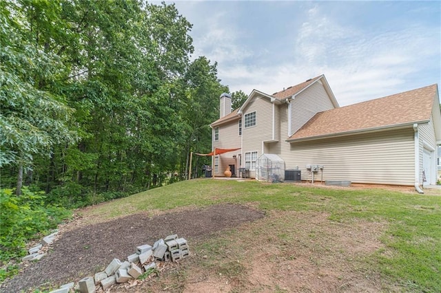 206 Belmont Dr, Monroe, GA 30655 - rear view of property with cooling unit, a yard, a chimney, and roof with shingles