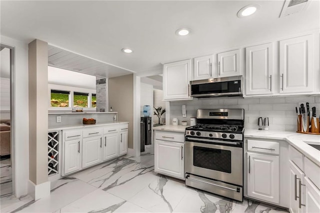 5219 Legendary Ln, Acworth, GA 30102 - kitchen with appliances with stainless steel finishes, white cabinetry, tasteful backsplash, recessed lighting, and light marble finish floors